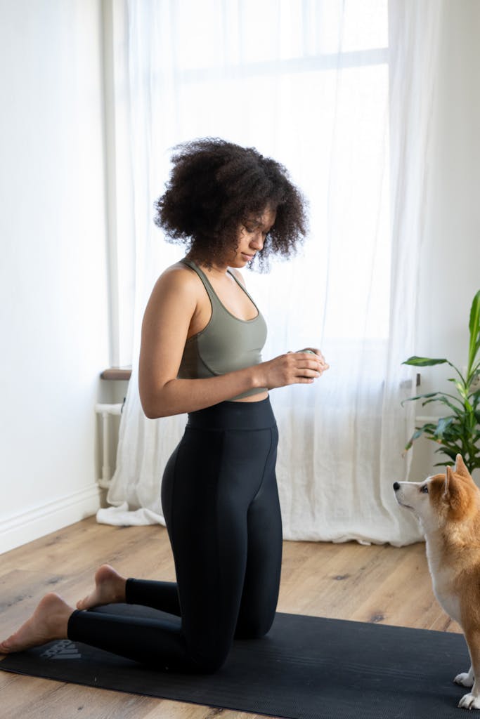 A woman practicing yoga with her dog at home, creating a peaceful and cozy atmosphere.