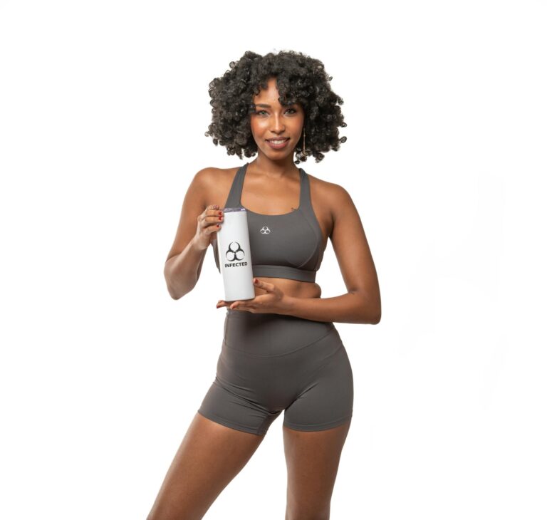 Athletic woman with sports bottle, wearing gray activewear on white background.
