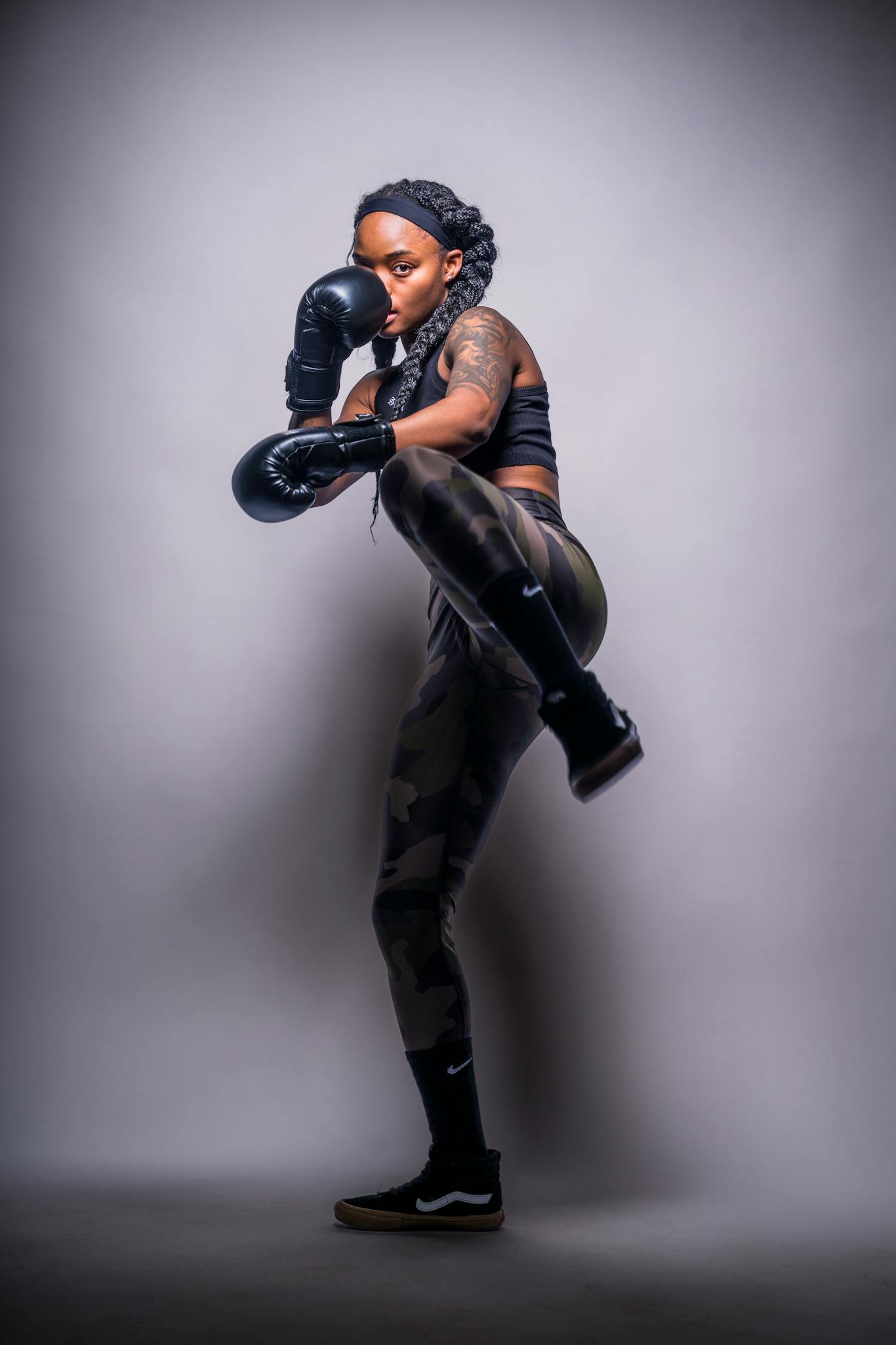 Strong and confident female boxer striking a pose with gloves and athletic attire.